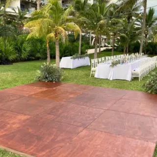 Wooden dance floor and wedding reception table on the garden lawn at Atelier Playa Mujeres, Cancun
