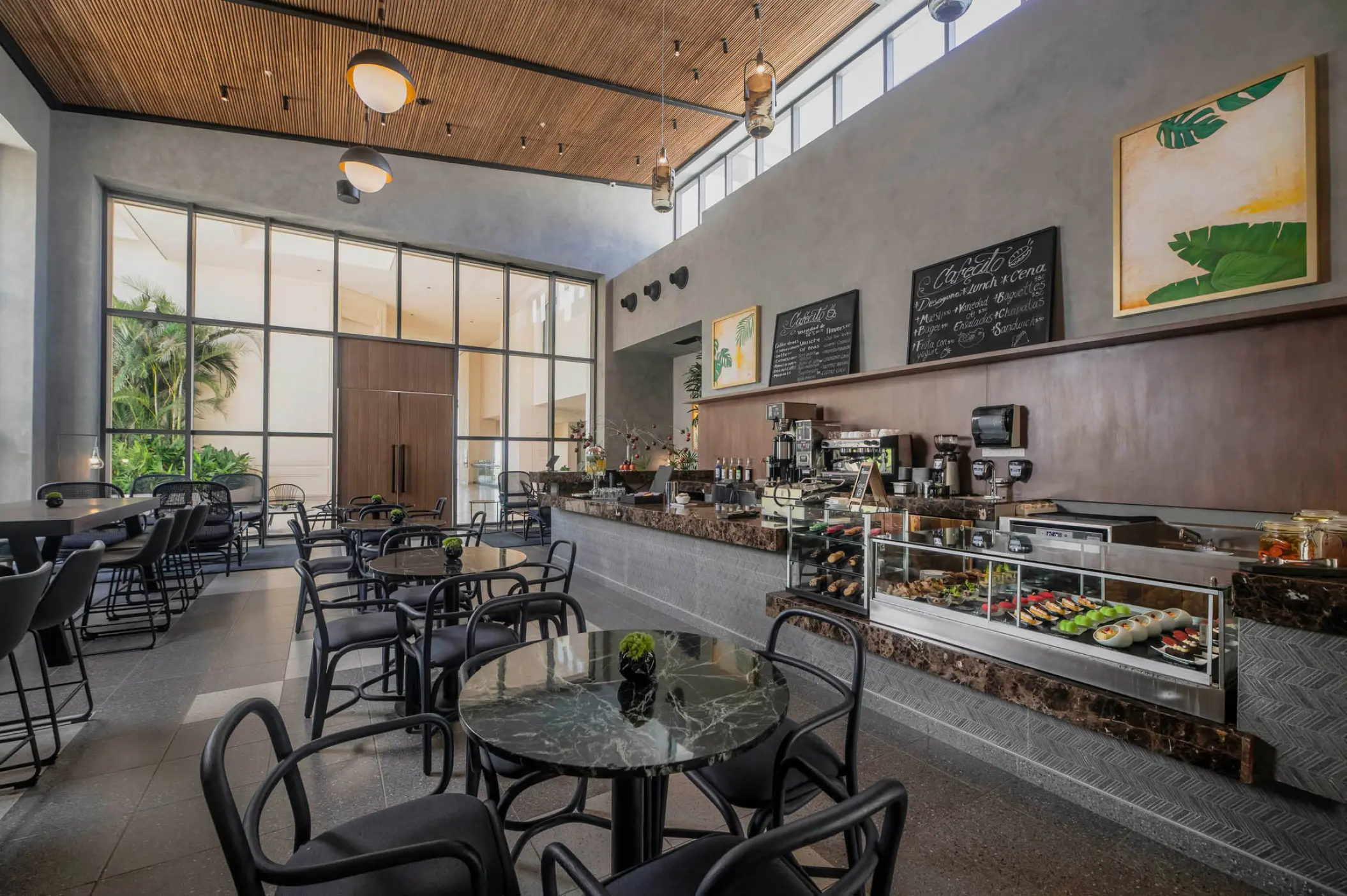 Cafecito coffee shop with modern seating and stone counters at Atelier Playa Mujeres, Cancun