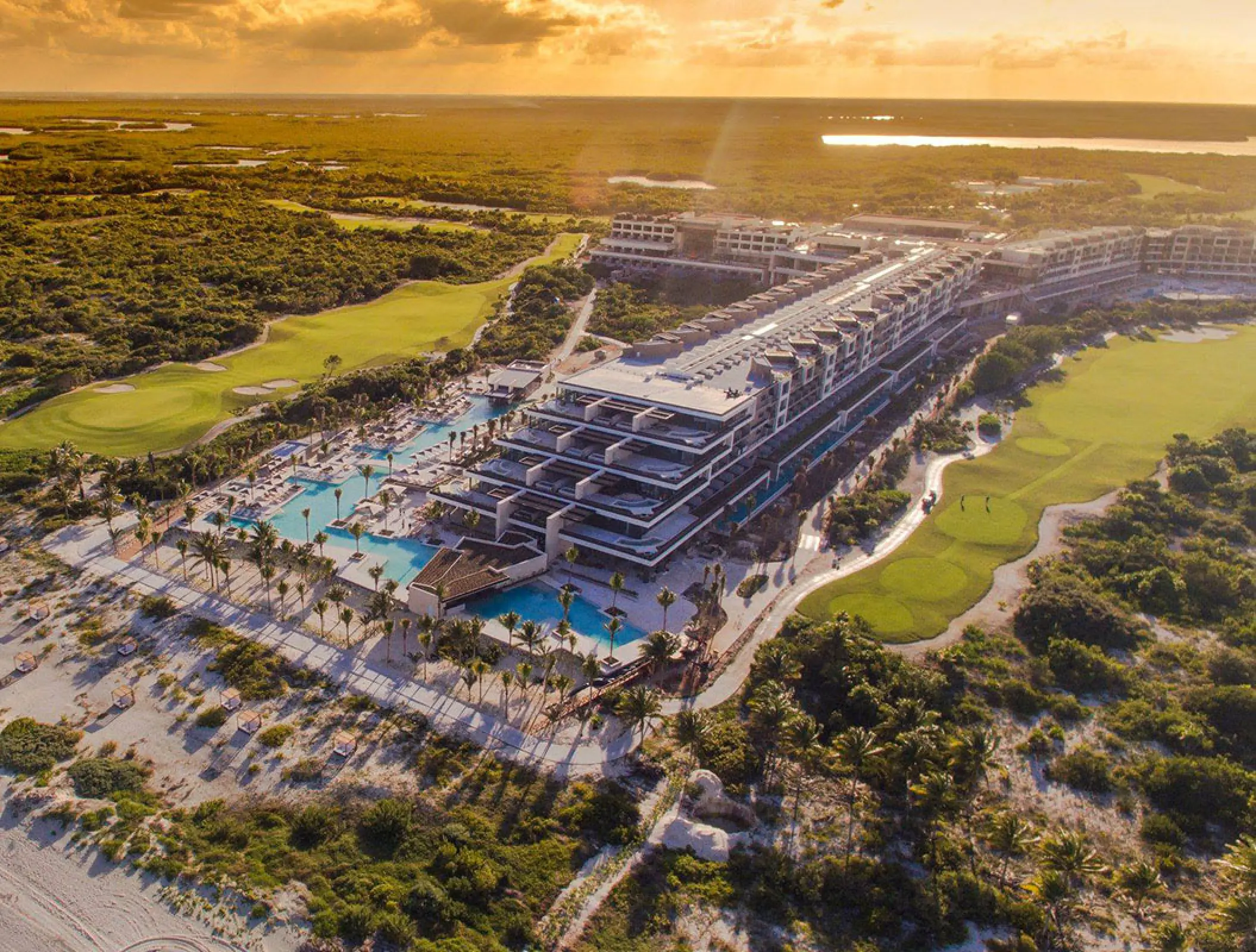 Aerial overview of Atelier Playa Mujeres property and pools at sunset, Cancun
