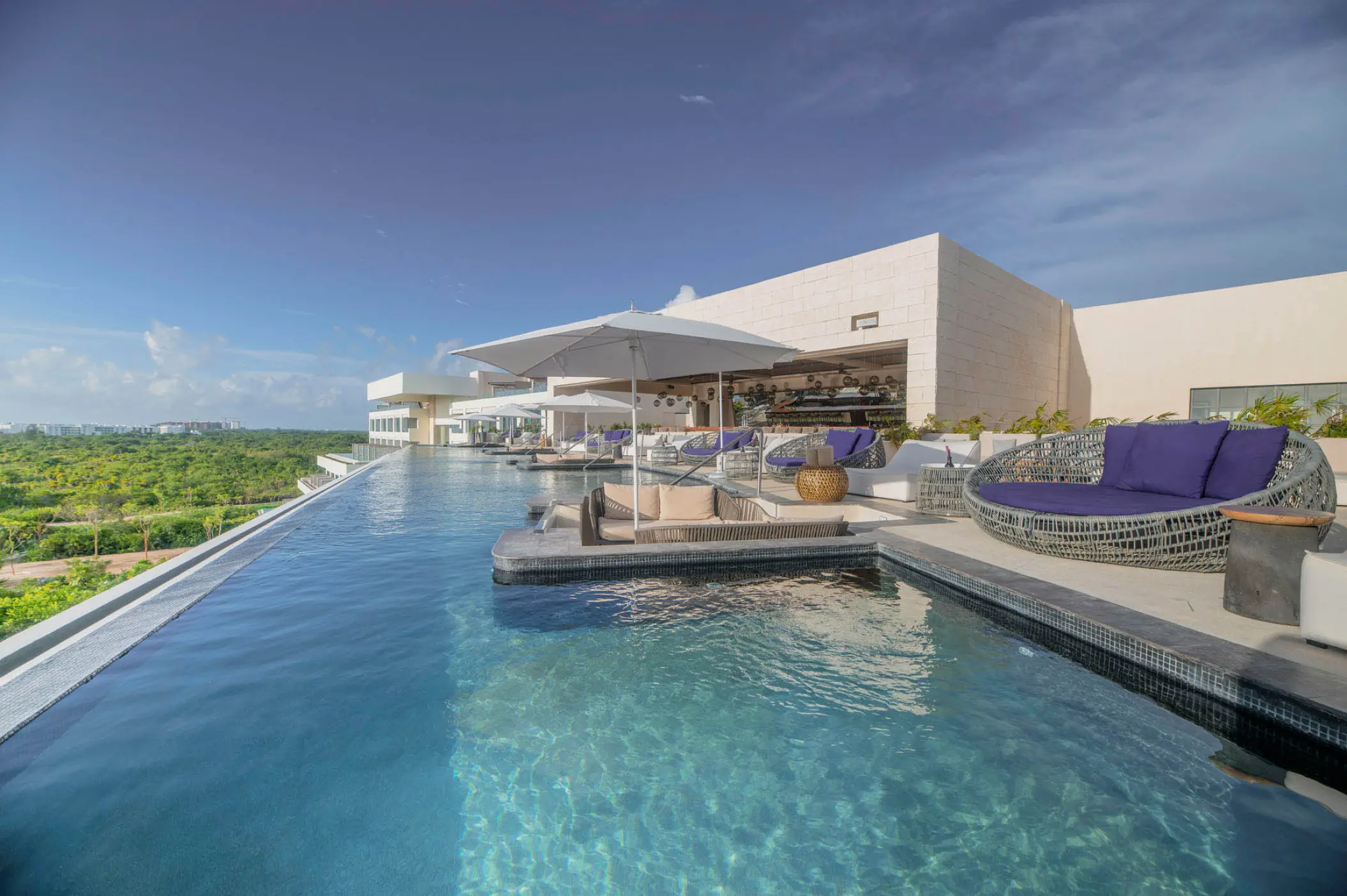 Rooftop infinity pool with lounge seating at Atelier Playa Mujeres, Cancun