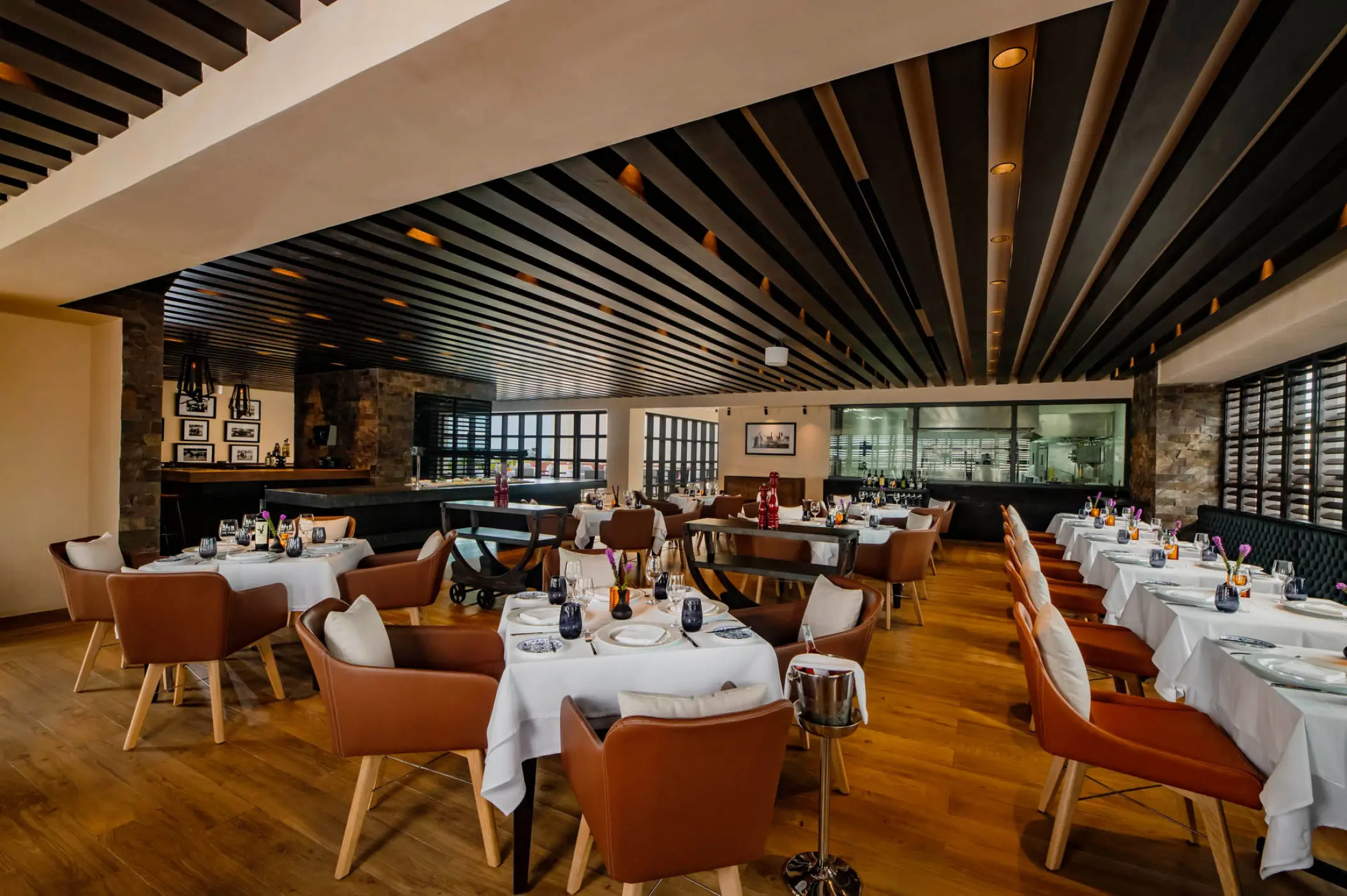 Los Abrazos restaurant with wood-slat ceilings and leather chairs at Atelier Playa Mujeres, Cancun