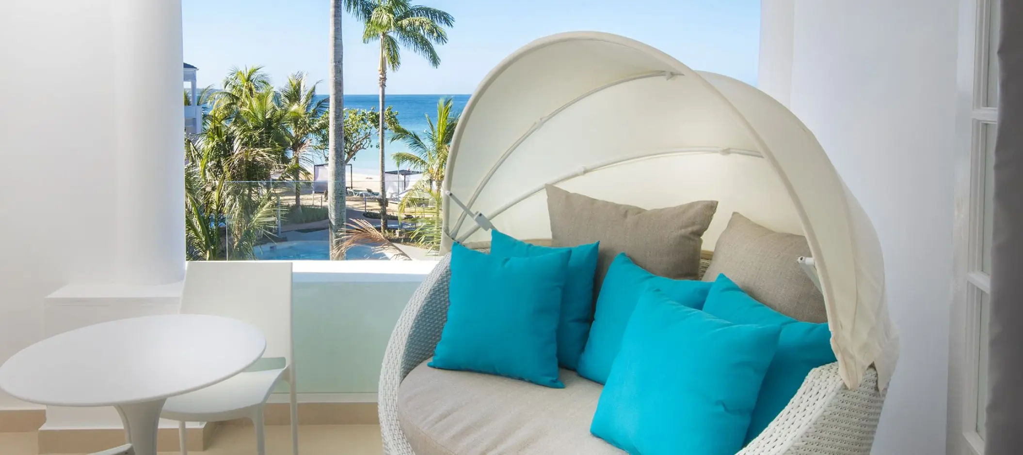 Private balcony with a hooded daybed and ocean views at Azul Beach Resort Negril