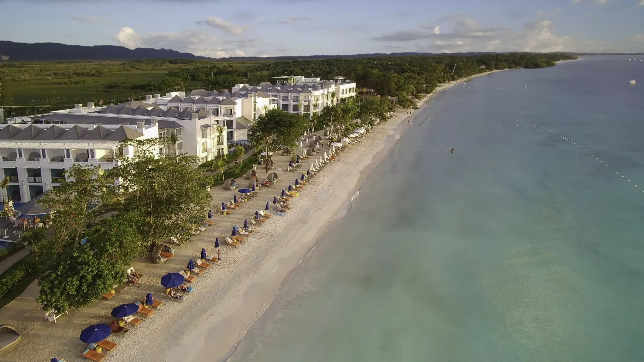 Aerial view of the white sand beach and beachfront buildings at Azul Beach Resort Negril, Negril