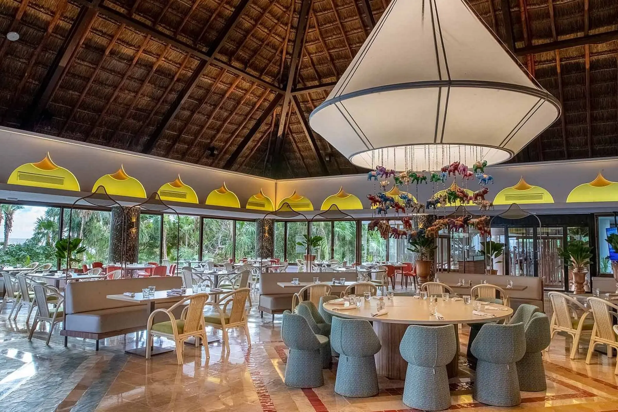 Modern restaurant dining room with a palapa roof at Bahia Principe Grand Tulum