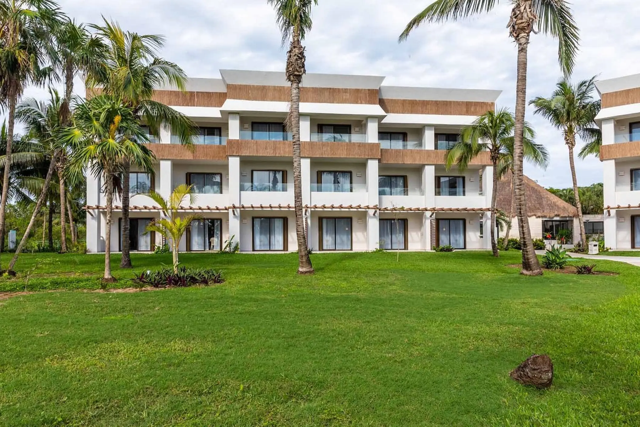 Bahia Principe Grand Tulum three-story guest room building and palm trees, Tulum