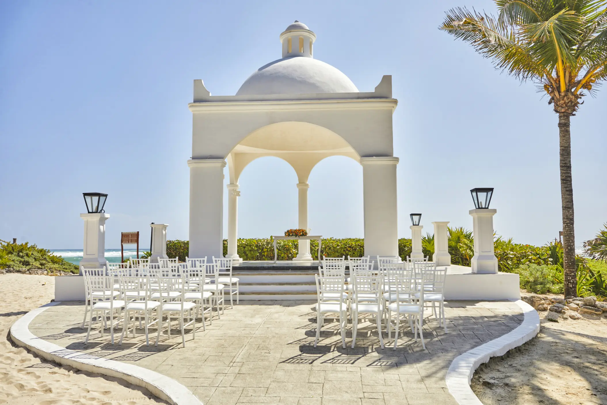 Beachfront wedding ceremony gazebo with white chairs at Bahia Principe Grand Tulum