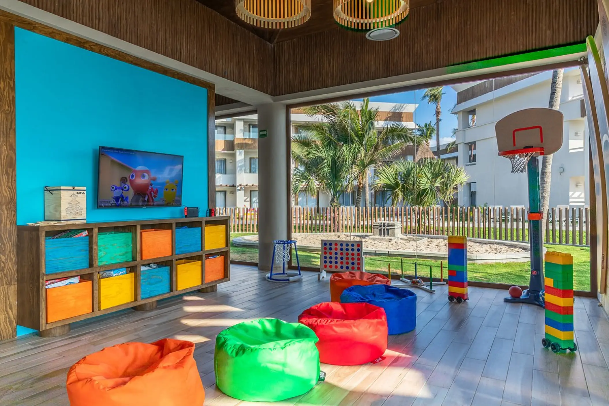 Kids club with colorful bean bags, games, and a basketball hoop at Bahia Principe Grand Tulum