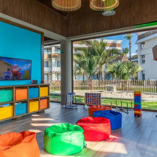 Kids club with colorful bean bags, games, and a basketball hoop at Bahia Principe Grand Tulum