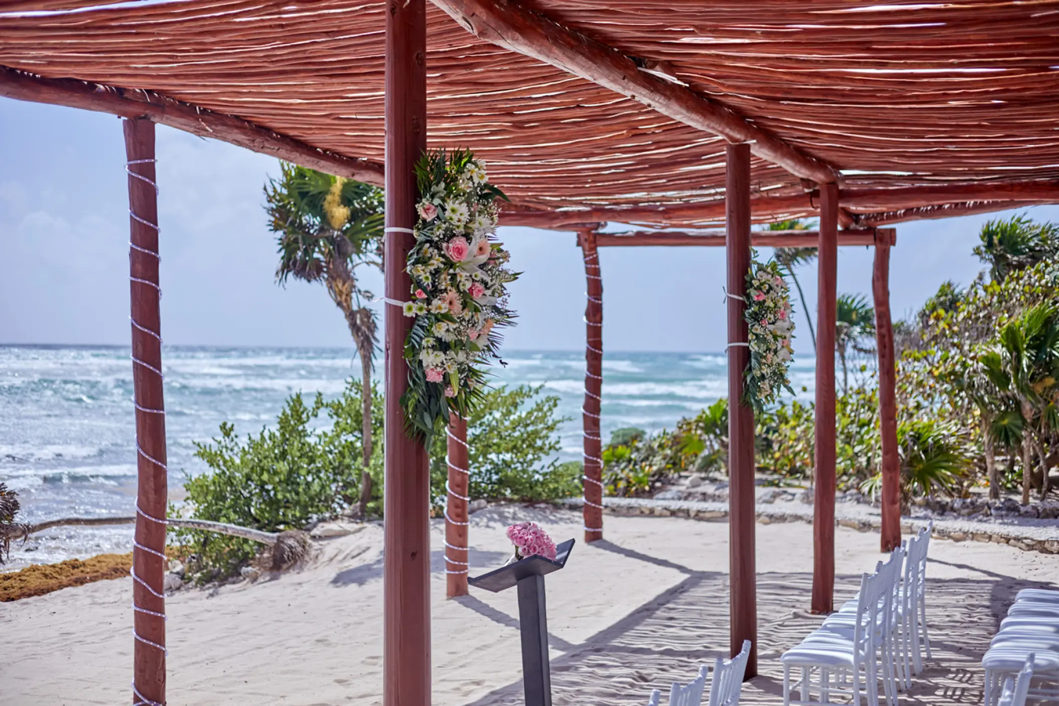 Beachfront wedding ceremony under a wooden pergola at Bahia Principe Grand Tulum