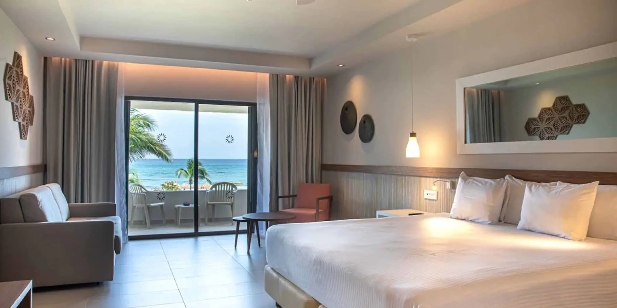Modern guest suite with ocean view balcony at Bahia Principe Grand Tulum