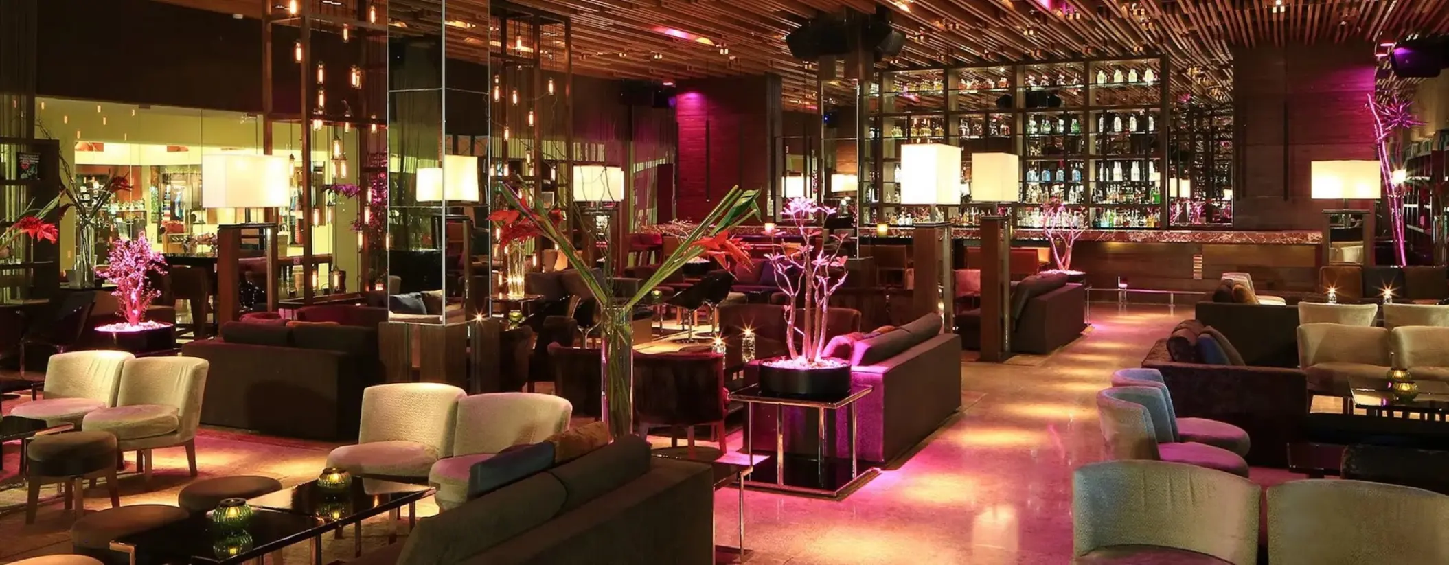 Modern cocktail lounge and bar area with purple accent lighting at Grand Velas Riviera Maya