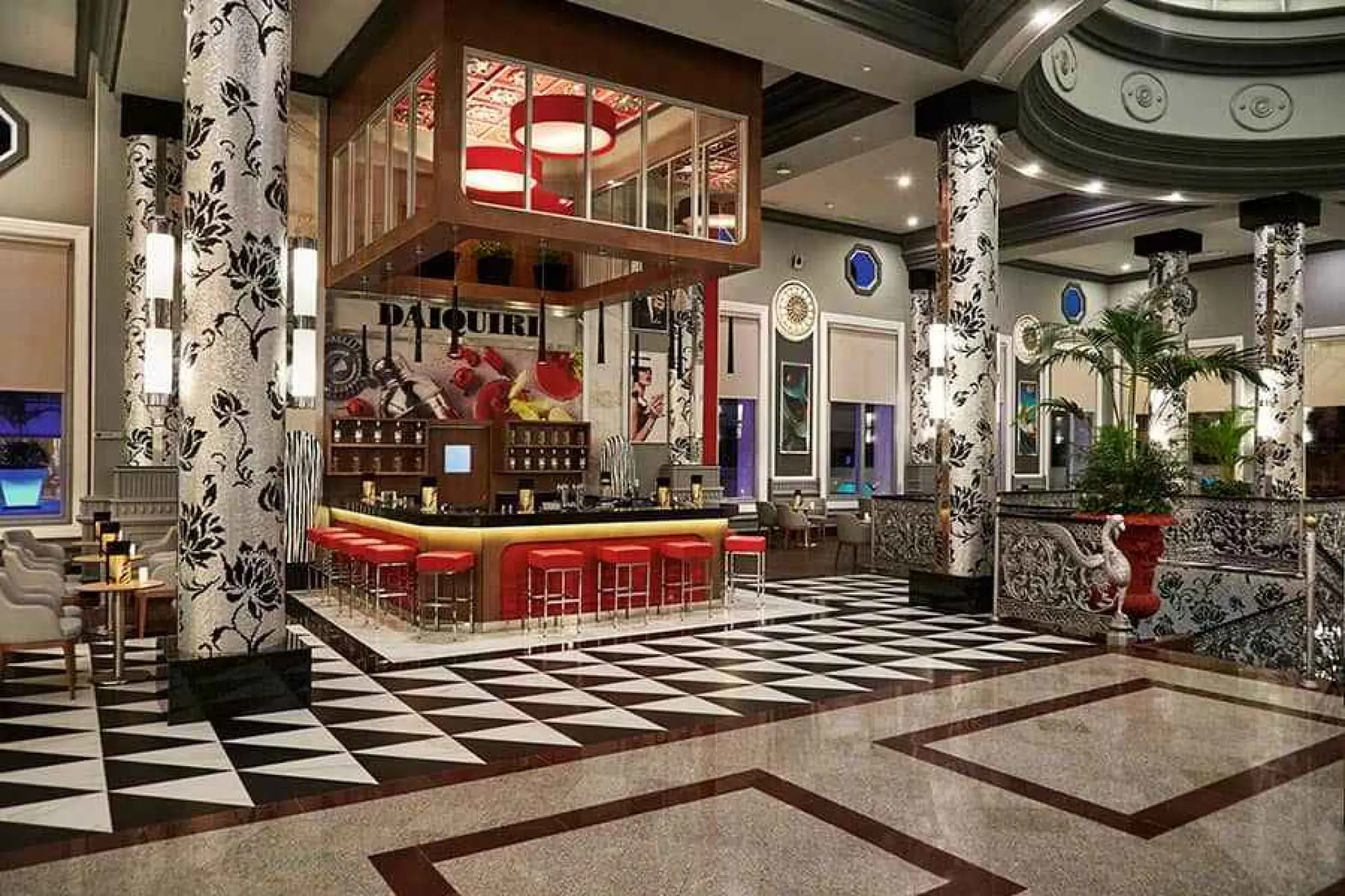Lobby bar area with red stools and patterned columns at Riu Palace Riviera Maya, Playa Del Carmen