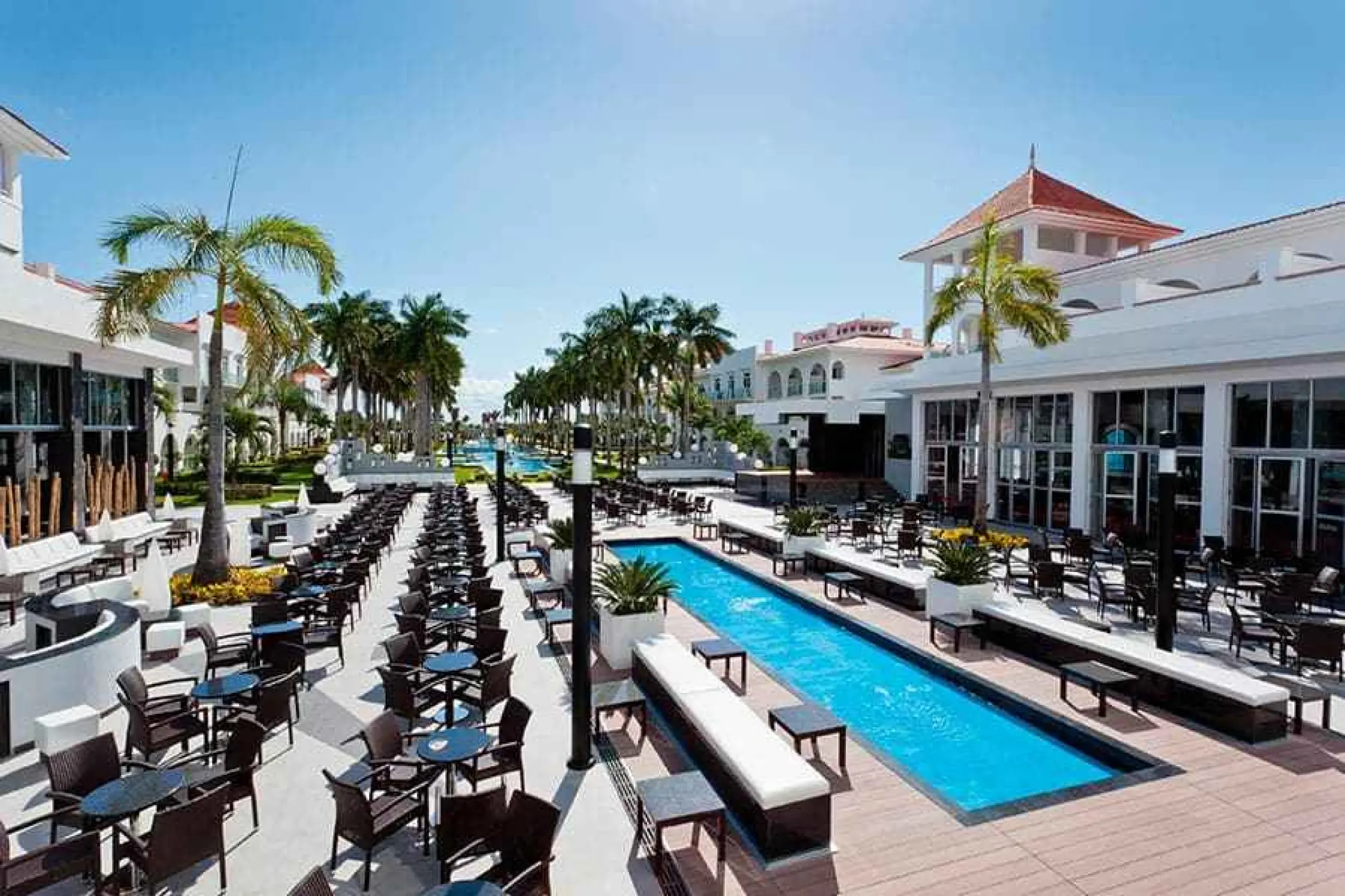 Outdoor terrace and bar seating with a reflection pool at Riu Palace Mexico, Playa Del Carmen