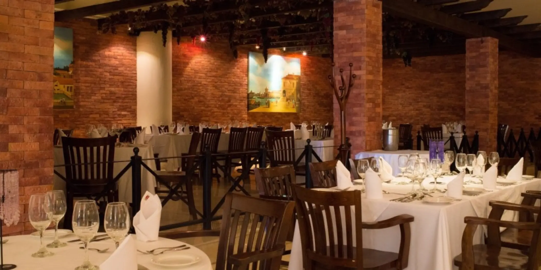 Indoor restaurant wedding reception with set tables and brick pillars at Barcelo Gran Faro, Cabo San Lucas