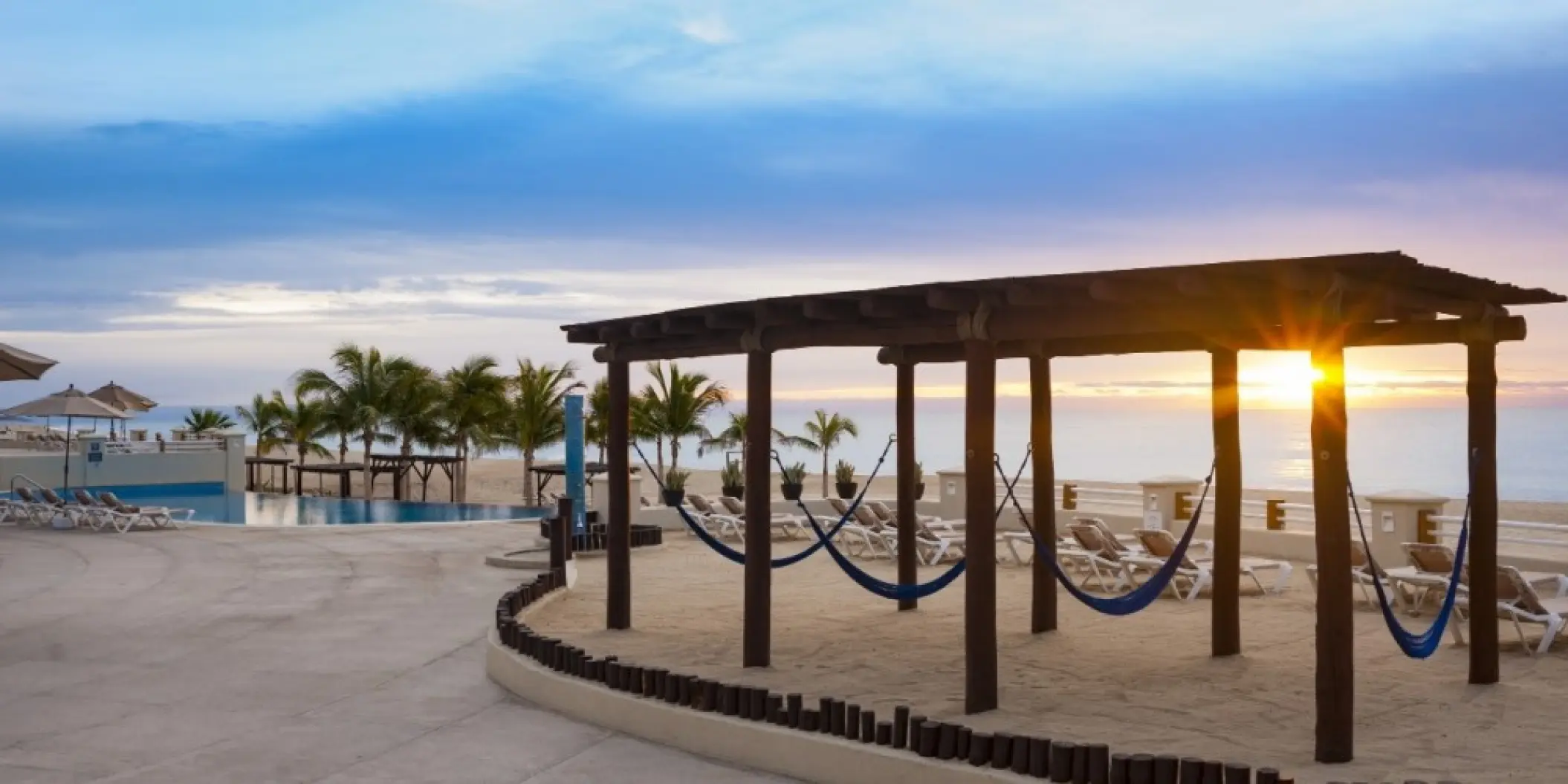 Beachfront hammocks under a wooden pergola at Barcelo Gran Faro, Cabo San Lucas