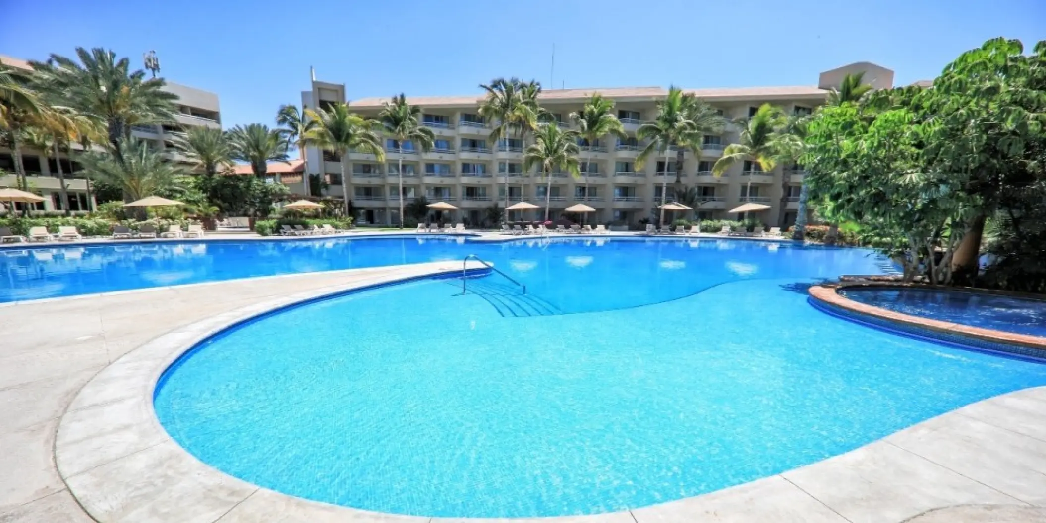 Barcelo Gran Faro Los Cabos main swimming pool surrounded by palm trees and resort buildings, Cabo San Lucas