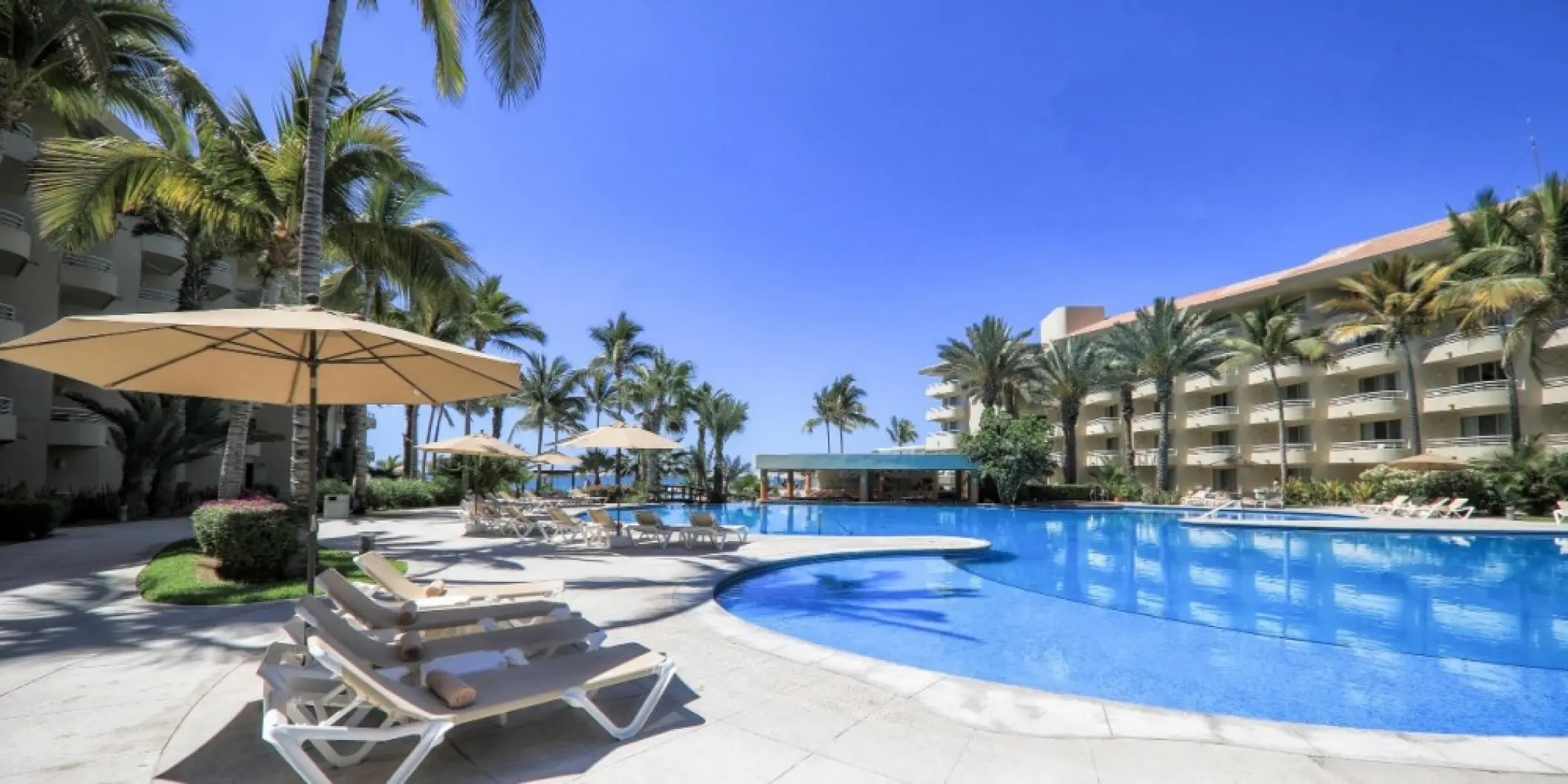 Large outdoor swimming pool and lounge chairs at Barcelo Gran Faro, Cabo San Lucas