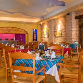 Indoor restaurant with striped linens and brick walls at Barcelo Gran Faro, Cabo San Lucas