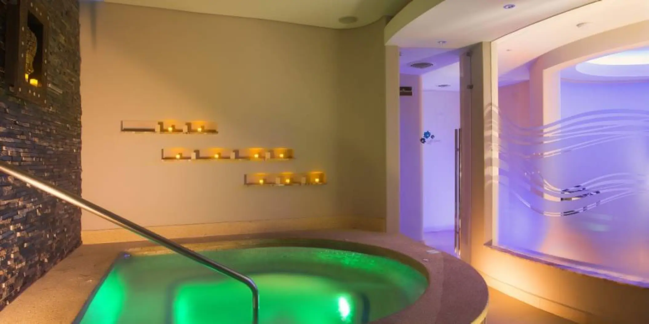 Indoor spa whirlpool with green lighting and candle wall at Barcelo Gran Faro, Cabo San Lucas