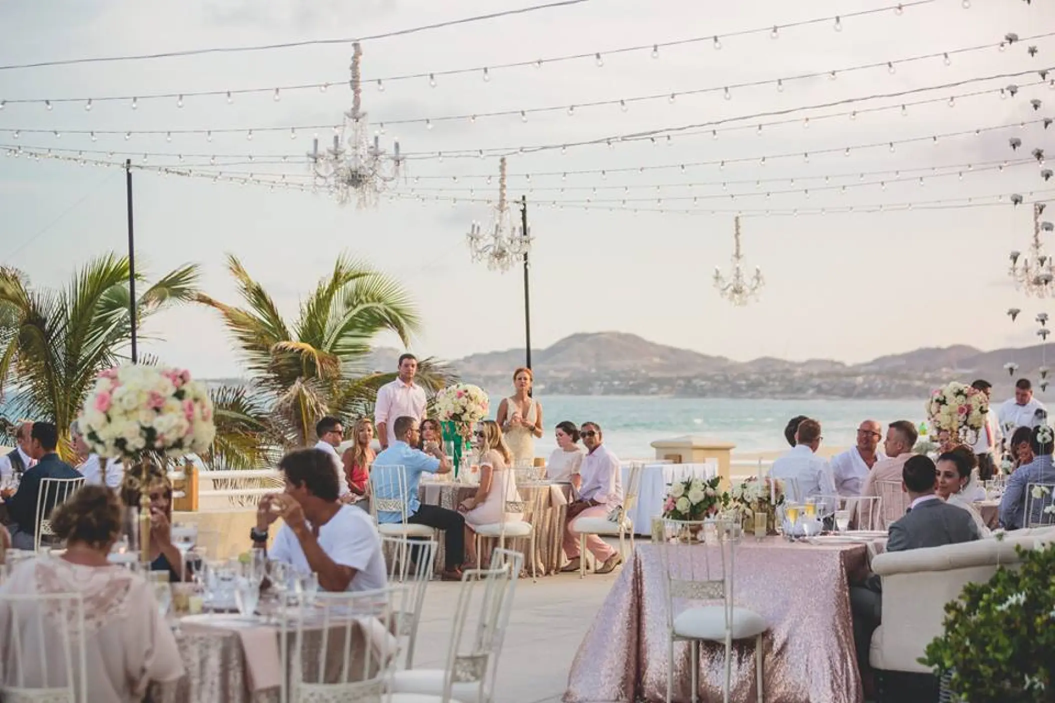 Rooftop wedding reception with chandeliers and string lights at Barcelo Gran Faro Los Cabos, Cabo San Lucas