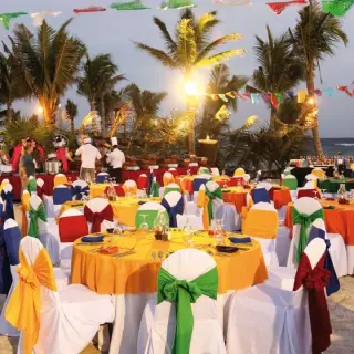Colorful beachfront wedding reception with papel picado banners and palm trees at Barcelo Maya Caribe, Riviera Maya