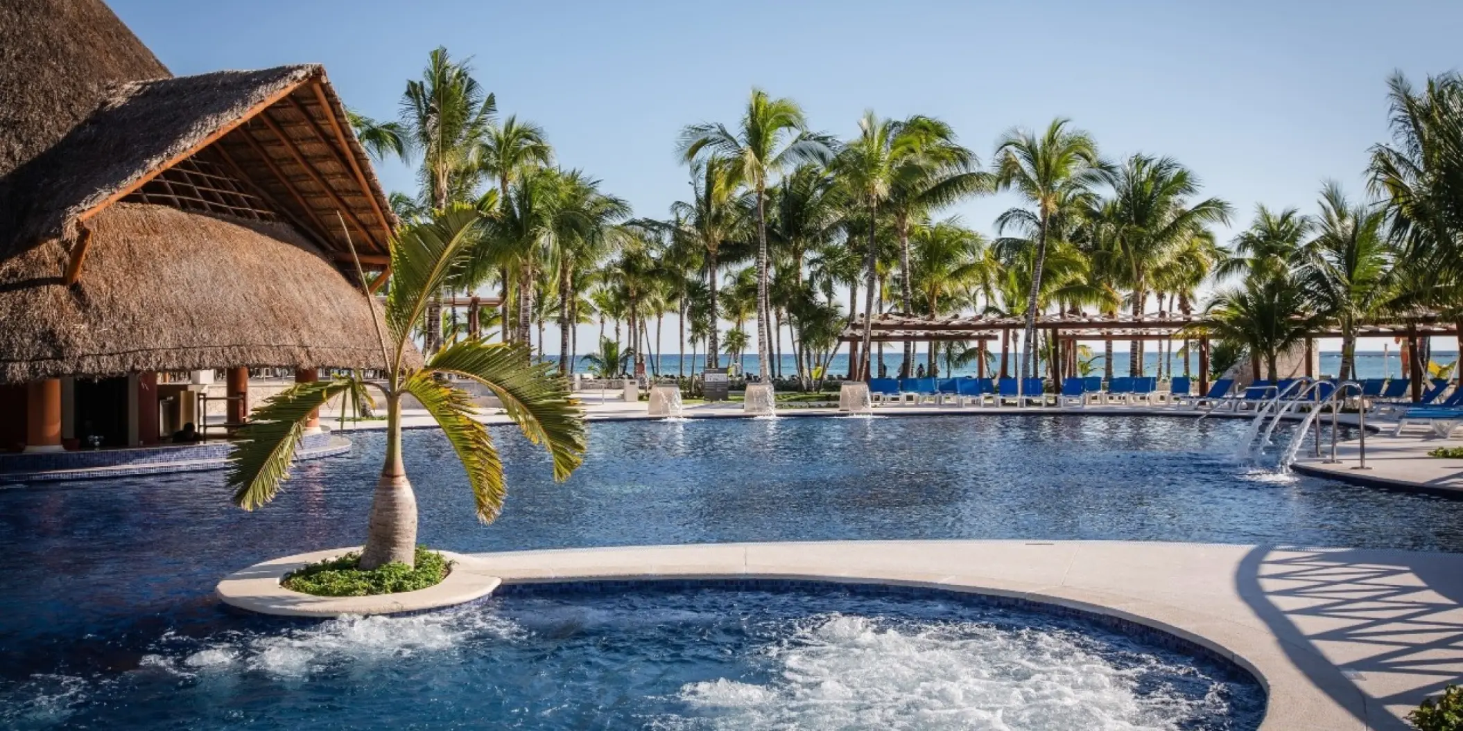 Barcelo Maya Caribe swimming pool with a swim-up bar and palm trees, Riviera Maya