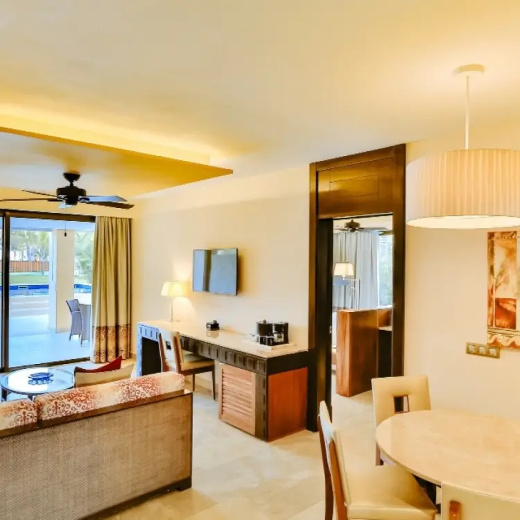 Modern swim-up suite living area with dining table and terrace at Barcelo Maya Caribe, Riviera Maya