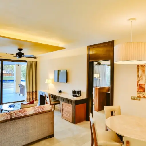 Modern swim-up suite living area with dining table and terrace at Barcelo Maya Caribe, Riviera Maya