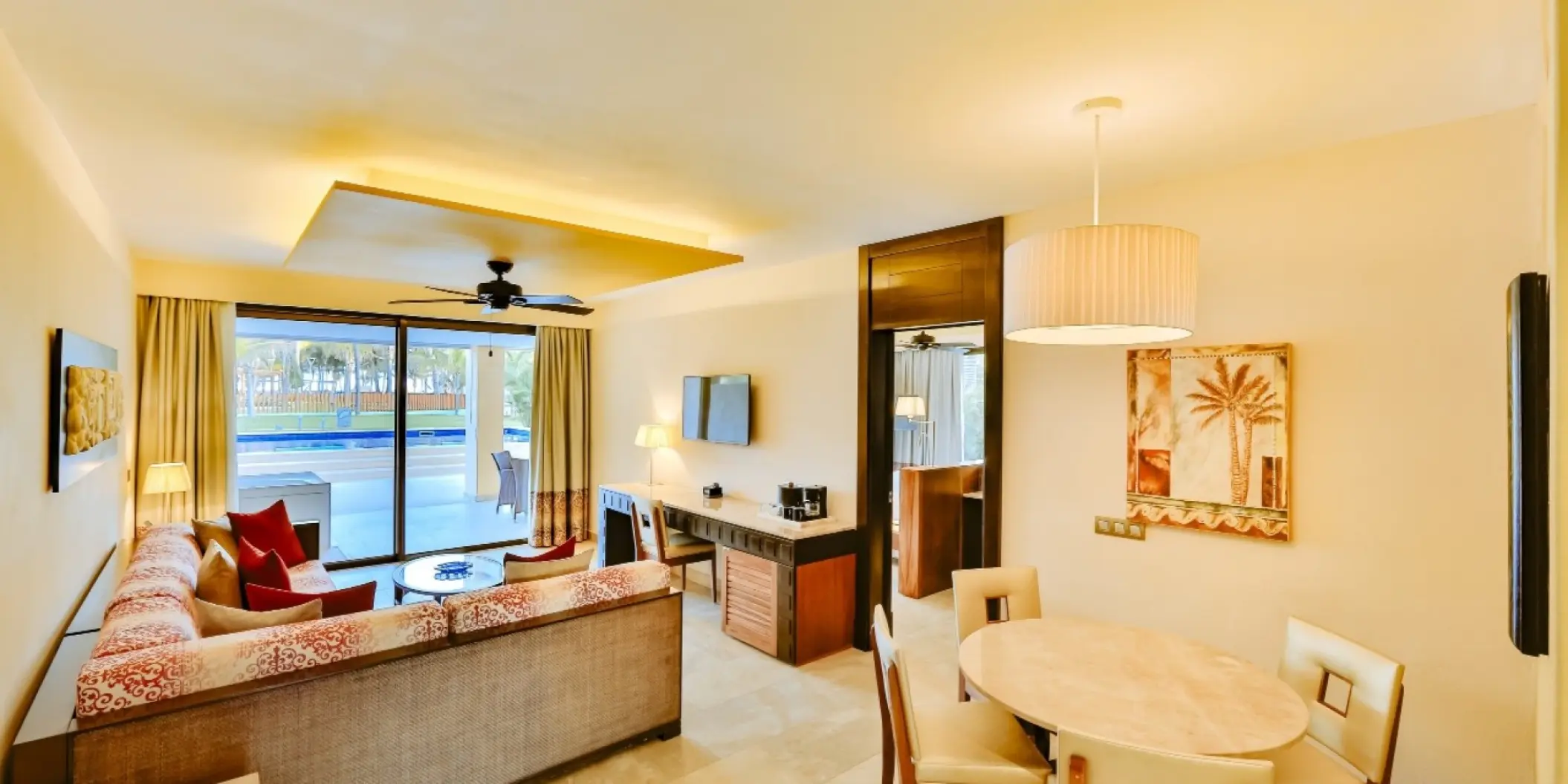 Modern swim-up suite living area with dining table and terrace at Barcelo Maya Caribe, Riviera Maya