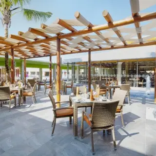 Outdoor restaurant terrace with a wooden pergola at Barcelo Maya Colonial, Riviera Maya