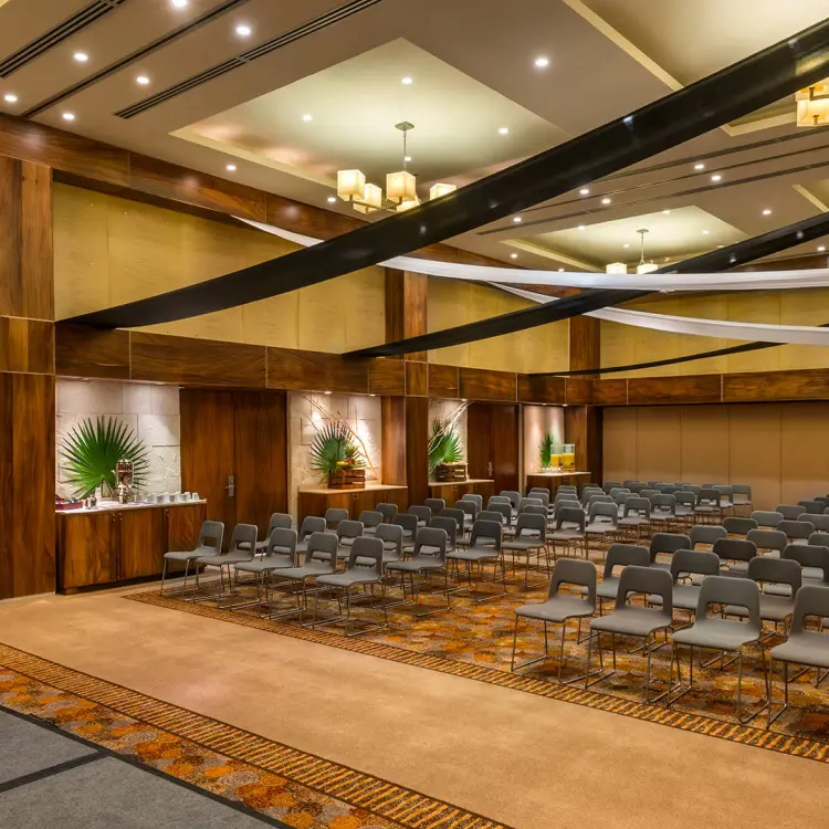Indoor wedding ceremony room with rows of chairs and a podium at Barcelo Maya Riviera, Playa Del Carmen