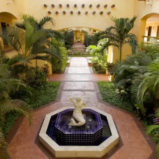 Barcelo Maya Tropical courtyard with lush palm trees and a central water fountain, Riviera Maya