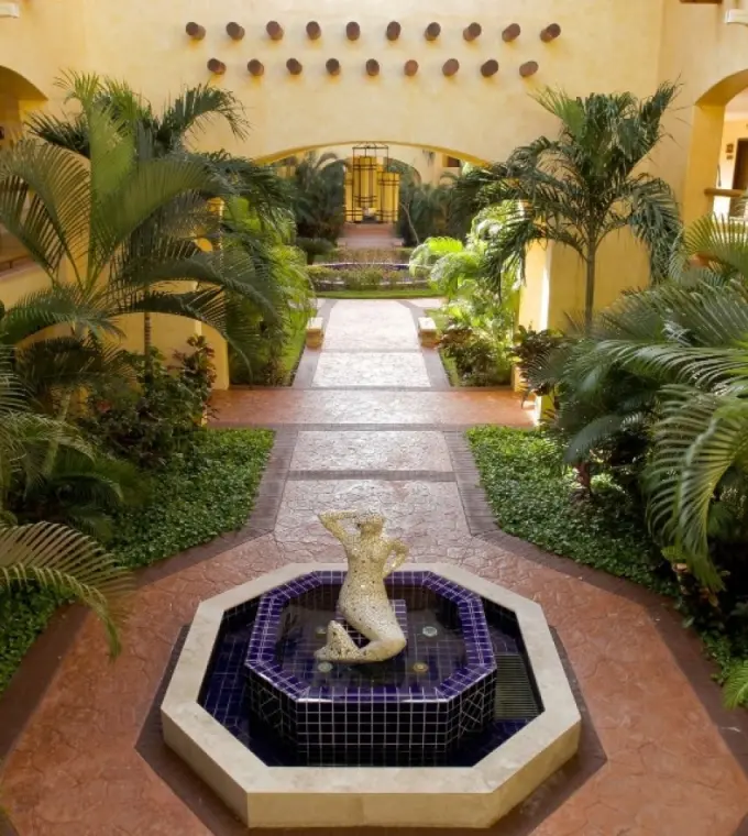 Barcelo Maya Tropical courtyard with lush palm trees and a central water fountain, Riviera Maya