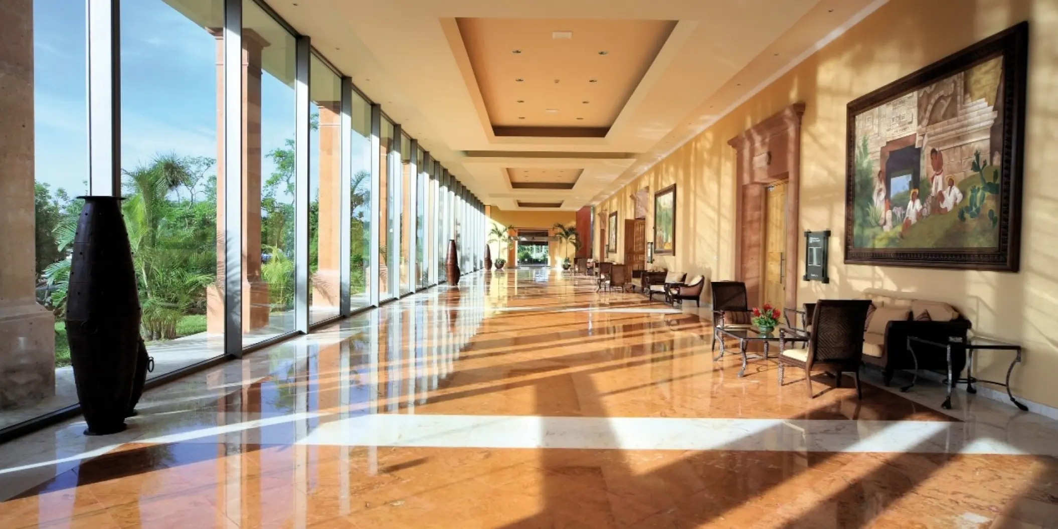 Polished marble hallway with floor-to-ceiling windows at Barcelo Maya Tropical, Riviera Maya
