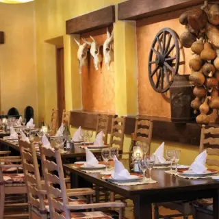 Rustic restaurant dining area with wooden wheels and skull decor at Barcelo Maya Tropical, Riviera Maya