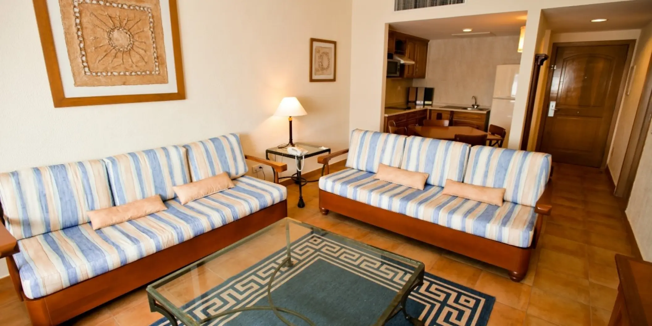 Barcelo Maya Tropical living area with striped sofas and kitchenette, Riviera Maya