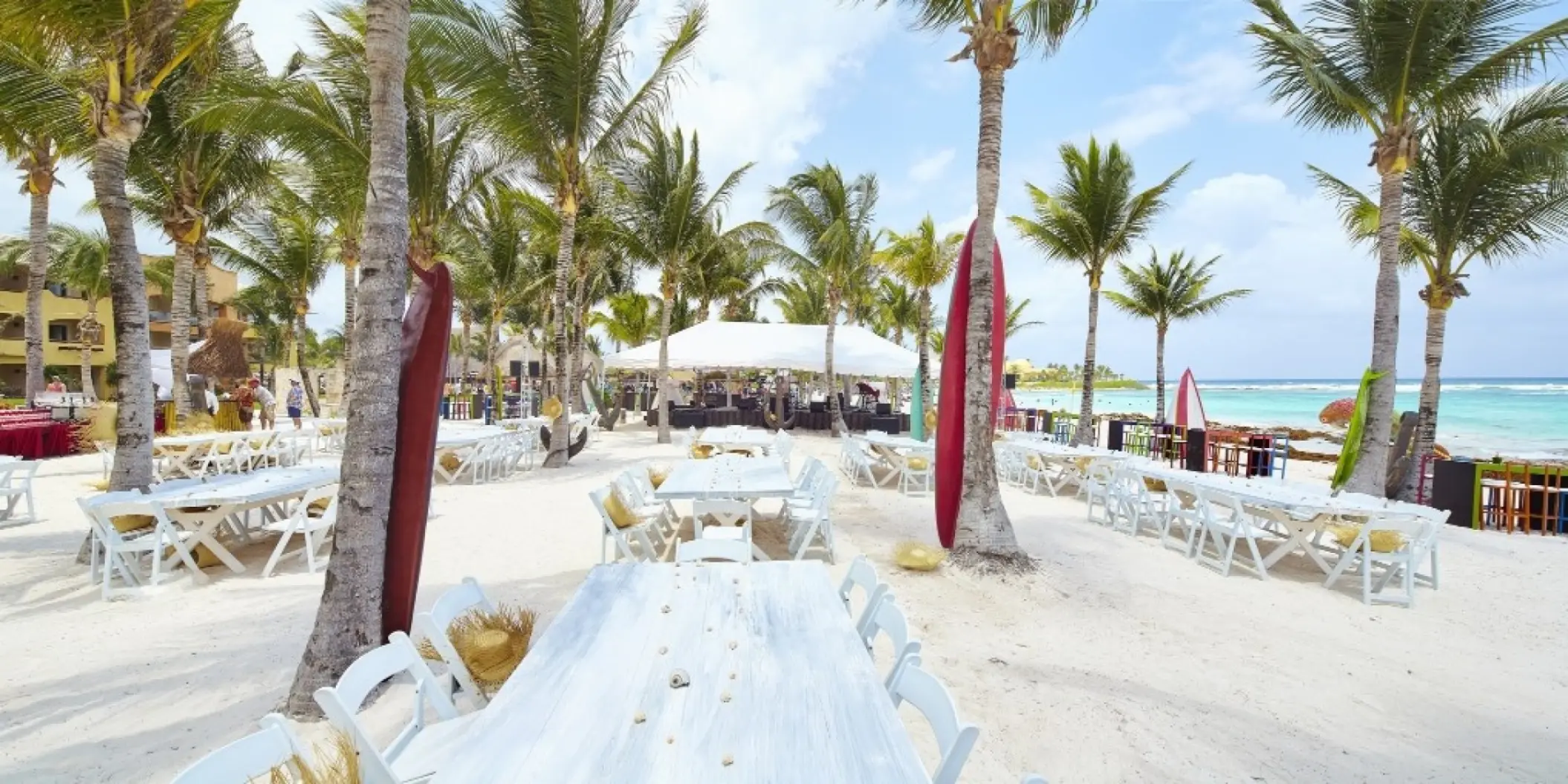 Beach wedding reception with white tables and palm trees at Barcelo Maya Riviera, Riviera Maya