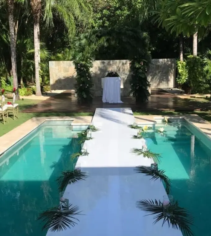 Poolside wedding ceremony with a white aisle walkway at Blue Diamond Luxury Boutique Hotel, Playa Del Carmen