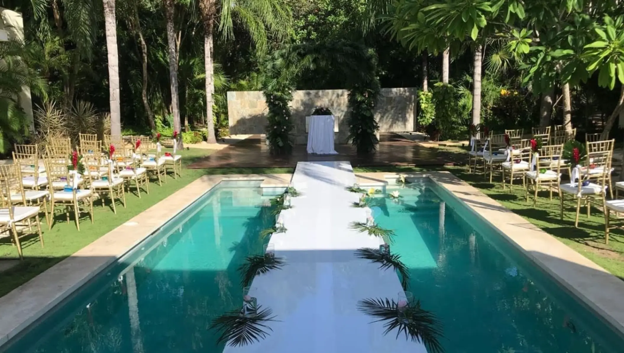 Poolside wedding ceremony with a white aisle walkway at Blue Diamond Luxury Boutique Hotel, Playa Del Carmen
