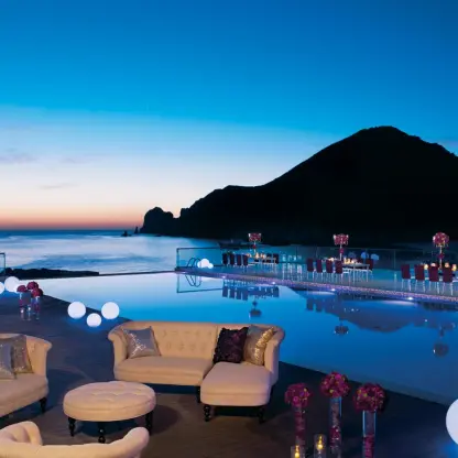 Freestyle pool area with lounge seating and orb lights at sunset at Breathless Cabo San Lucas