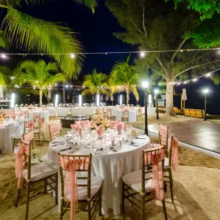 Nighttime beach wedding reception setup with string lights and a dance floor at Breathless Montego Bay