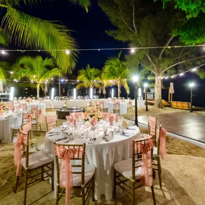 Nighttime beach wedding reception setup with string lights and a dance floor at Breathless Montego Bay