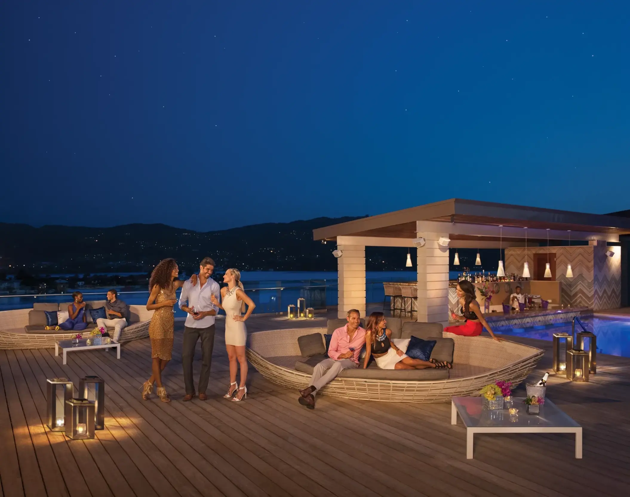 Friends socializing on the Altitude Deck at night at Breathless Montego Bay, Montego Bay