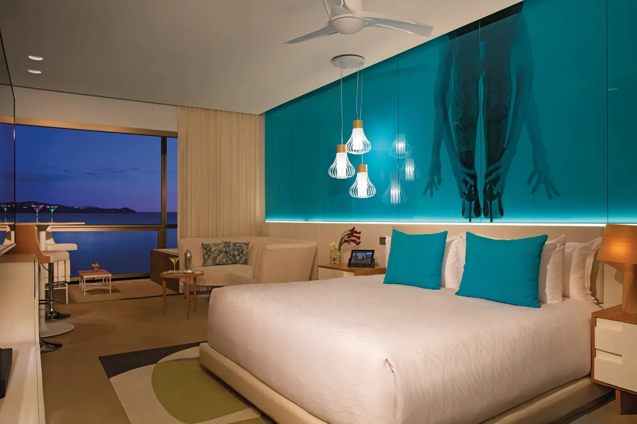 Junior Suite at Breathless Montego Bay with turquoise accents and a private balcony overlooking the ocean at night