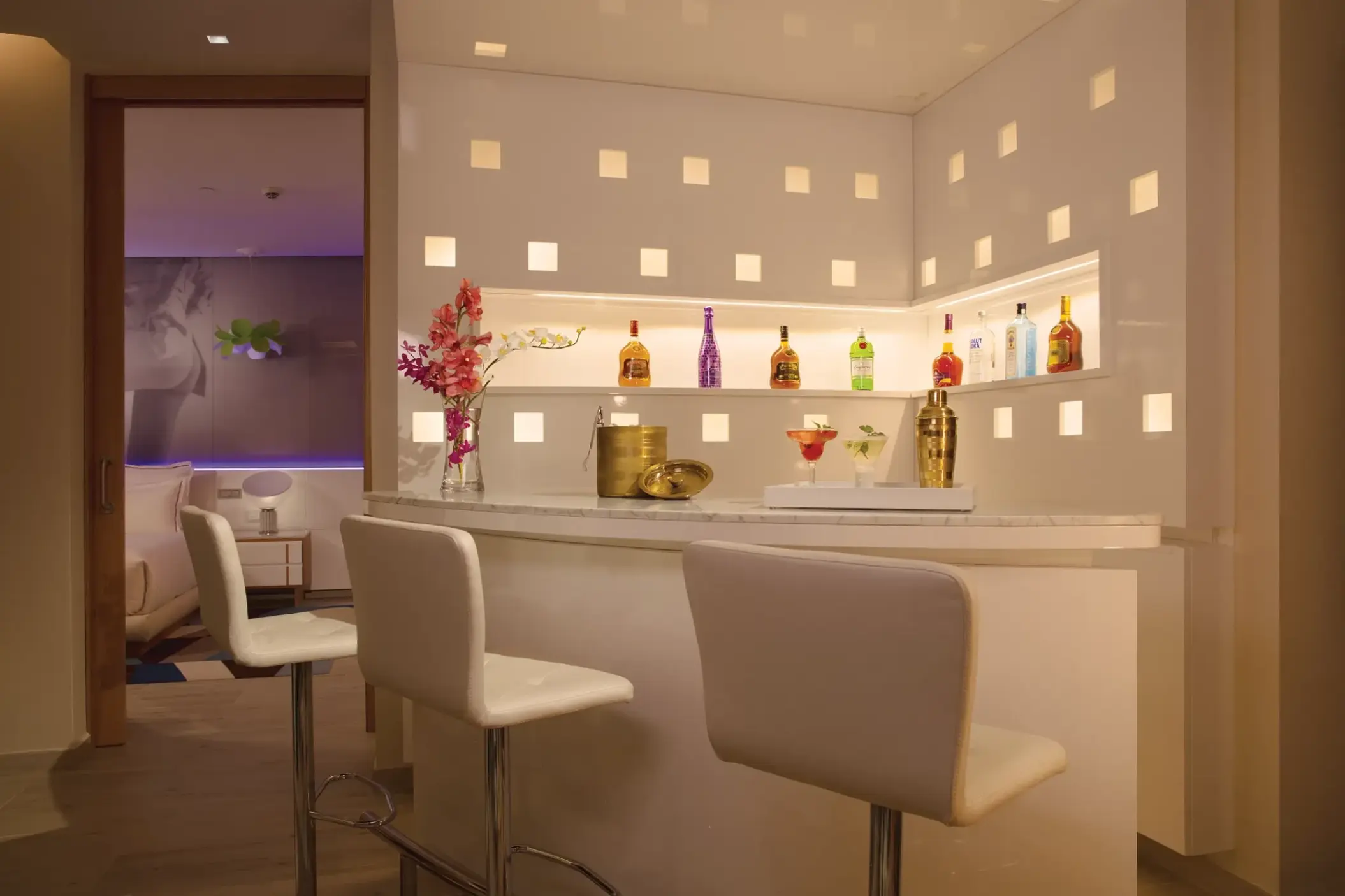Modern white suite bar with stools and backlit shelves at Breathless Montego Bay, Montego Bay