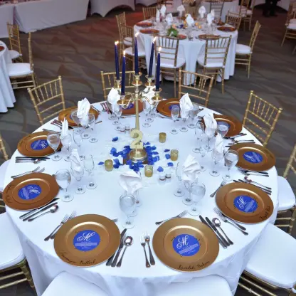 Indoor wedding reception at Breathless Montego Bay, Jamaica with gold charger plates and blue candle centerpieces
