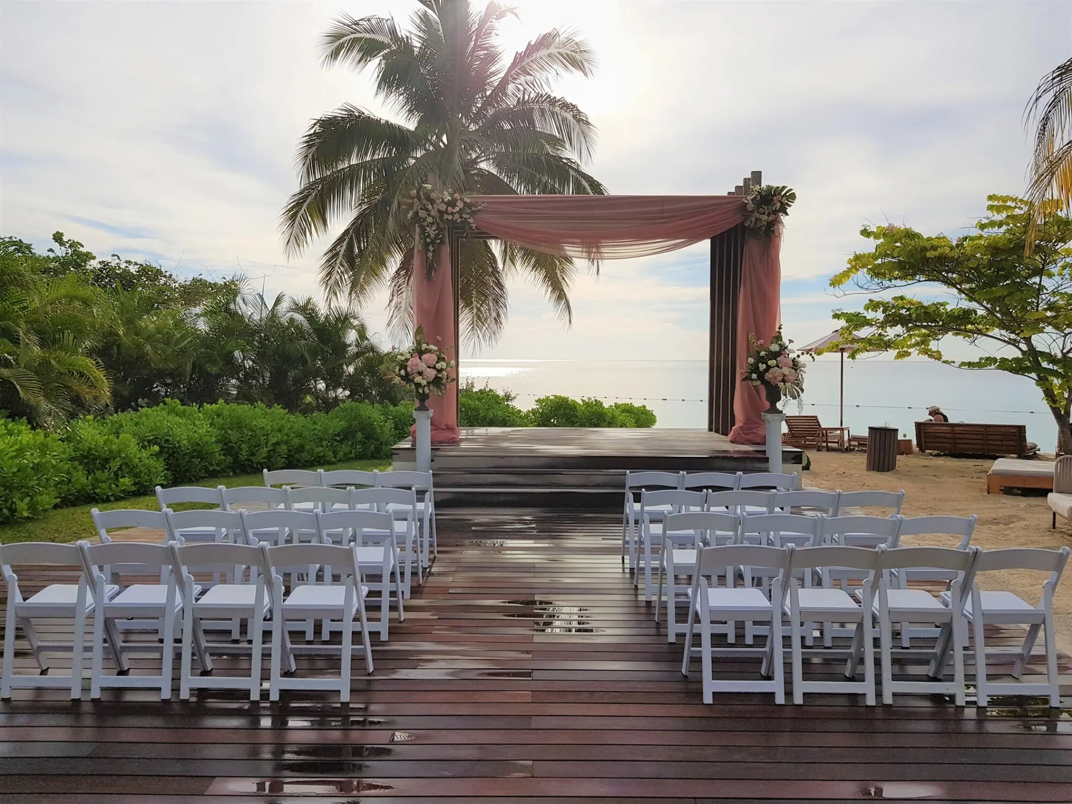 Beachfront wedding ceremony setup with pink draped gazebo and white chairs at Breathless Montego Bay, Jamaica