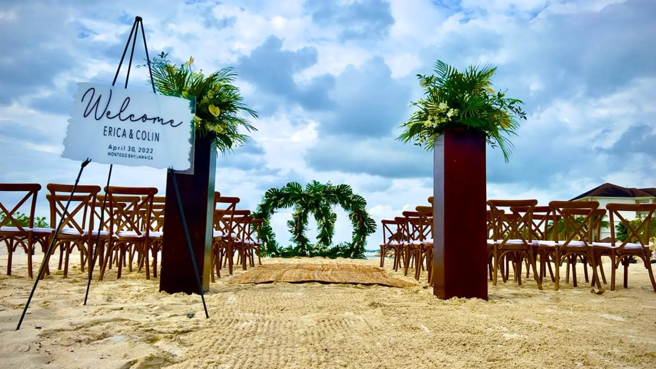 Beachfront wedding ceremony with circular greenery arch at Breathless Montego Bay, Jamaica