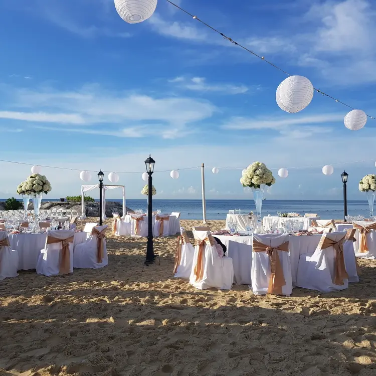Beach wedding reception with white lanterns and floral centerpieces at Breathless Montego Bay