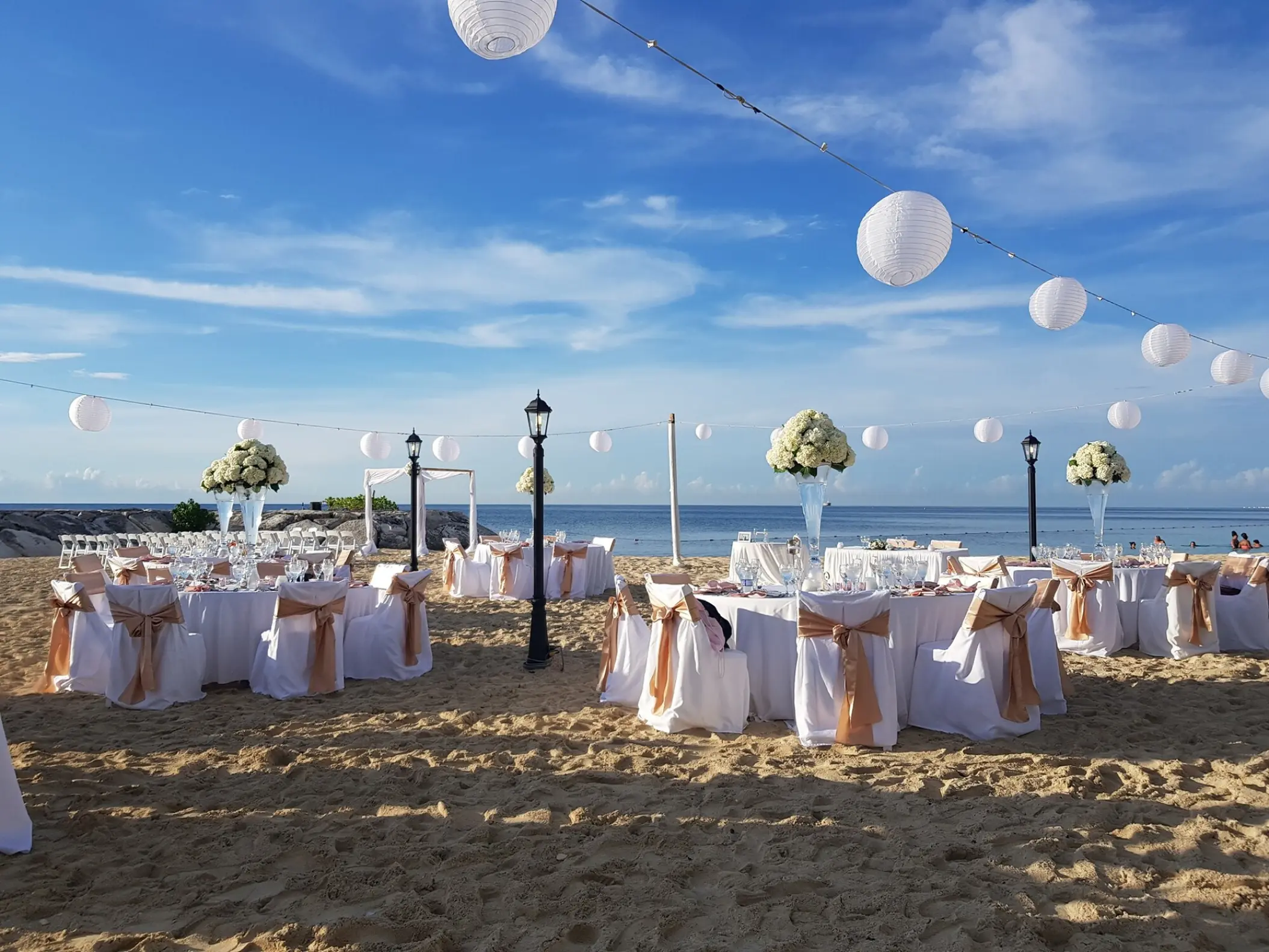 Beach wedding reception with white lanterns and floral centerpieces at Breathless Montego Bay